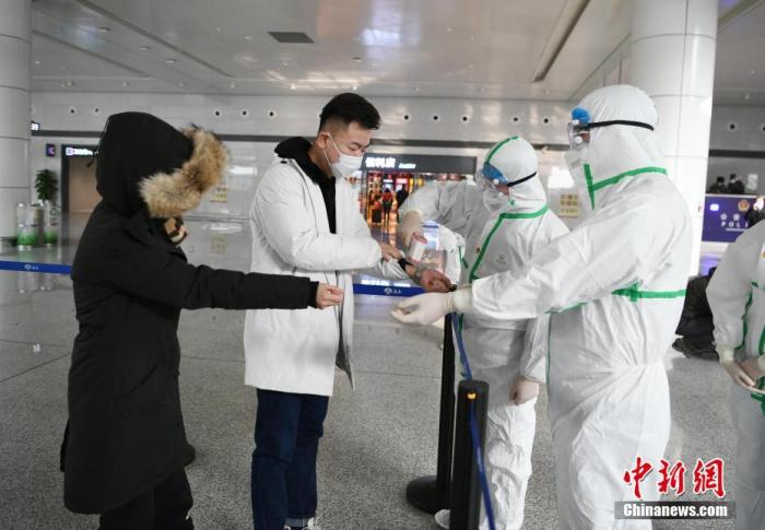2月1日，长春龙嘉机场，工作人员为旅客测量体温。受新型冠状病毒感染的肺炎疫情影响，机场内的工作人员和志愿者们每日对机场内区域进行专项消毒、测量旅客体温等工作，以防控疫情。/p中新社记者 张瑶 摄
